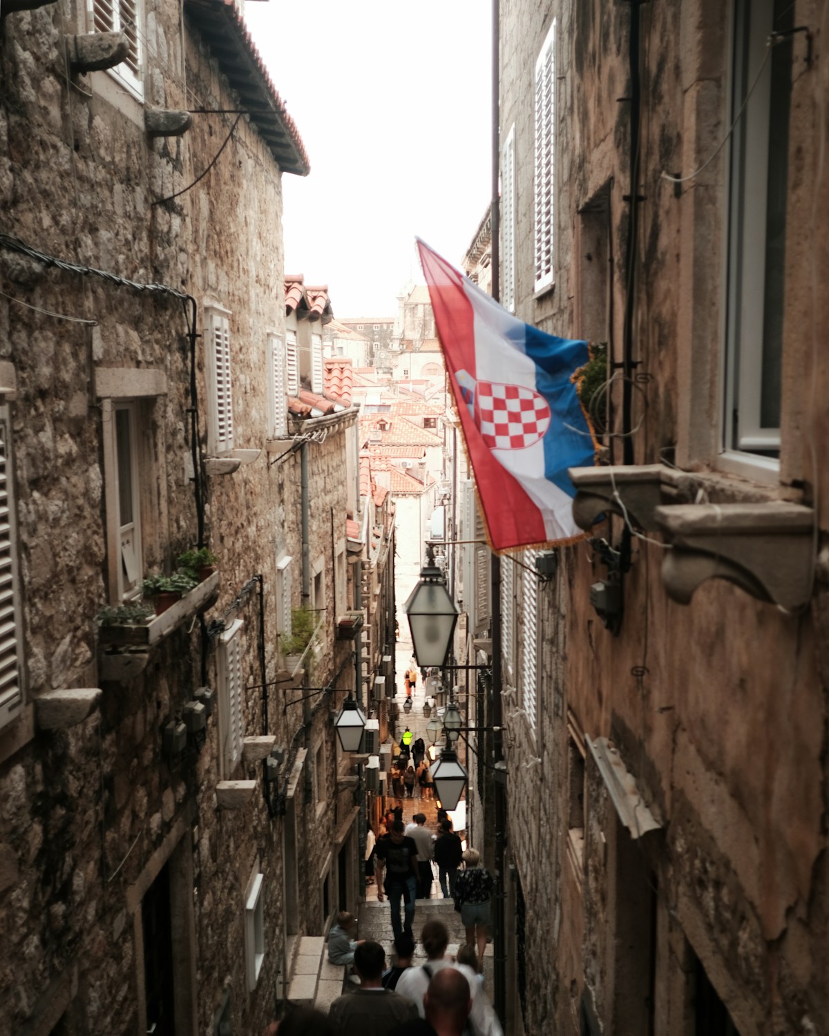Narrow cobblestone street with people in Dubrovnik old town, Croatia