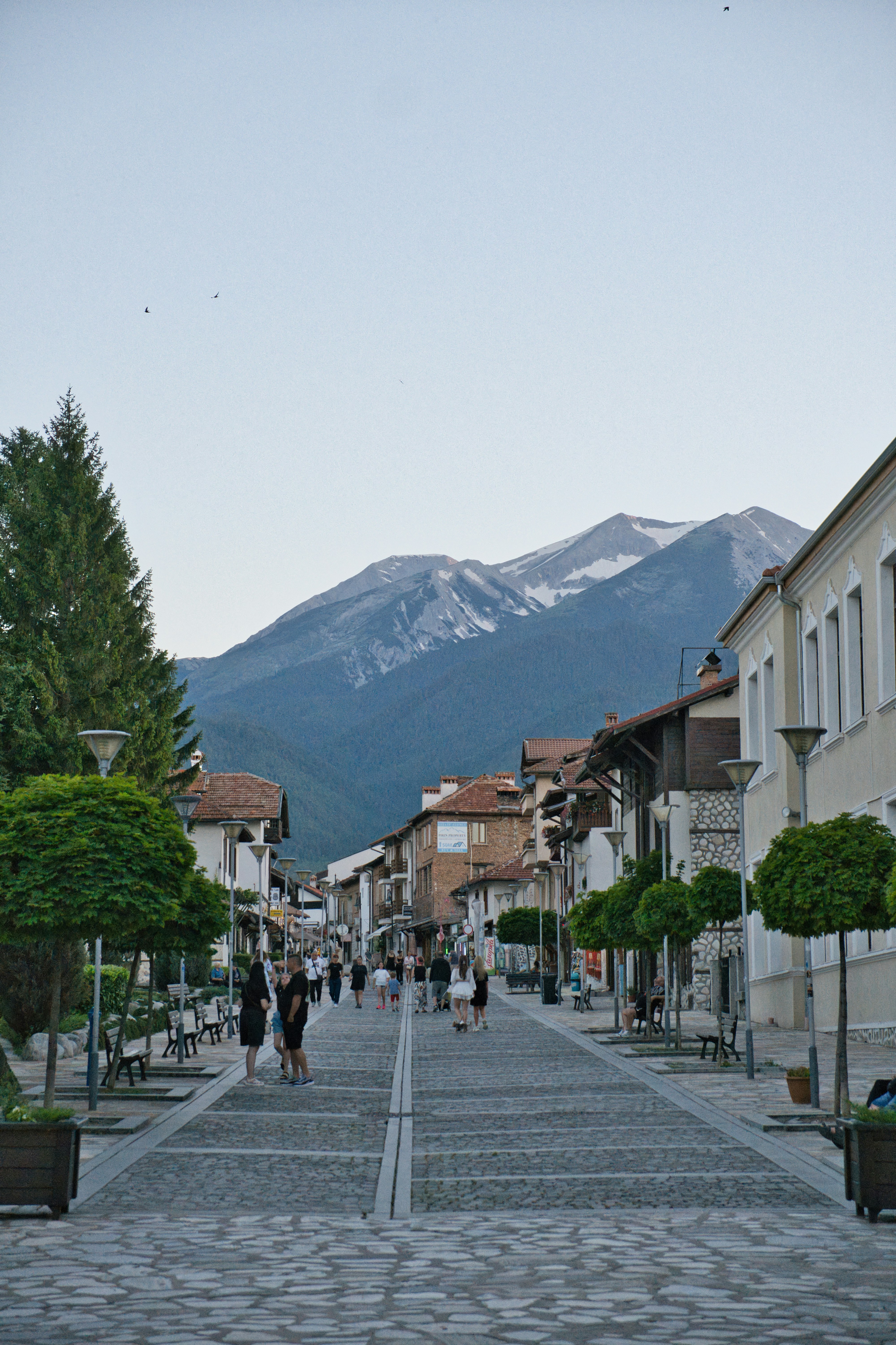 Cobblestone pedestrian street in Bansko with Pirin mountain peak behind, Bulgaria