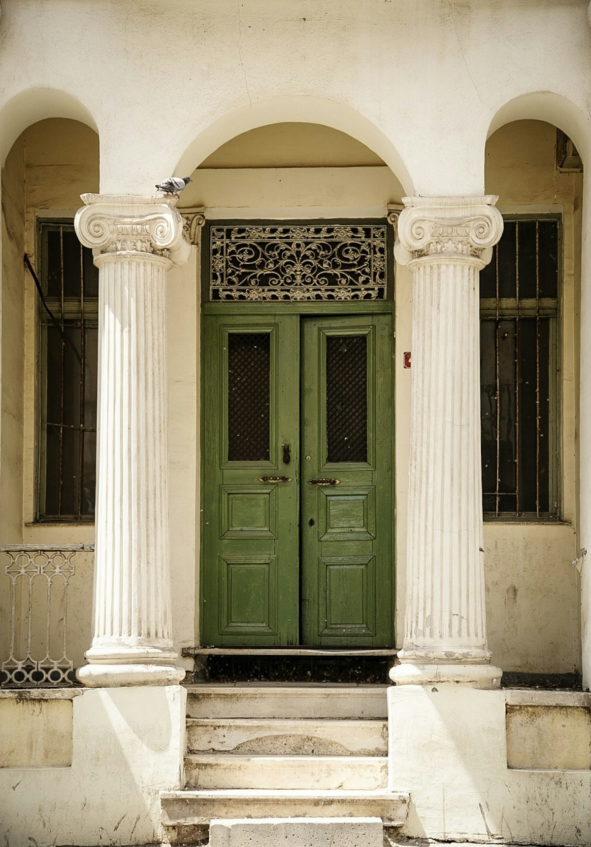Ornate green double door with white Ionic columns in Bitola, North Macedonia