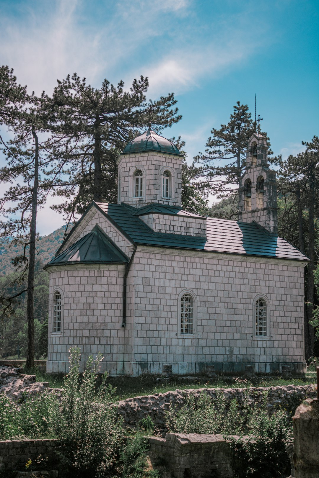 Historic white Orthodox church surrounded by pine trees in Cetinje, Montenegro's old royal capital