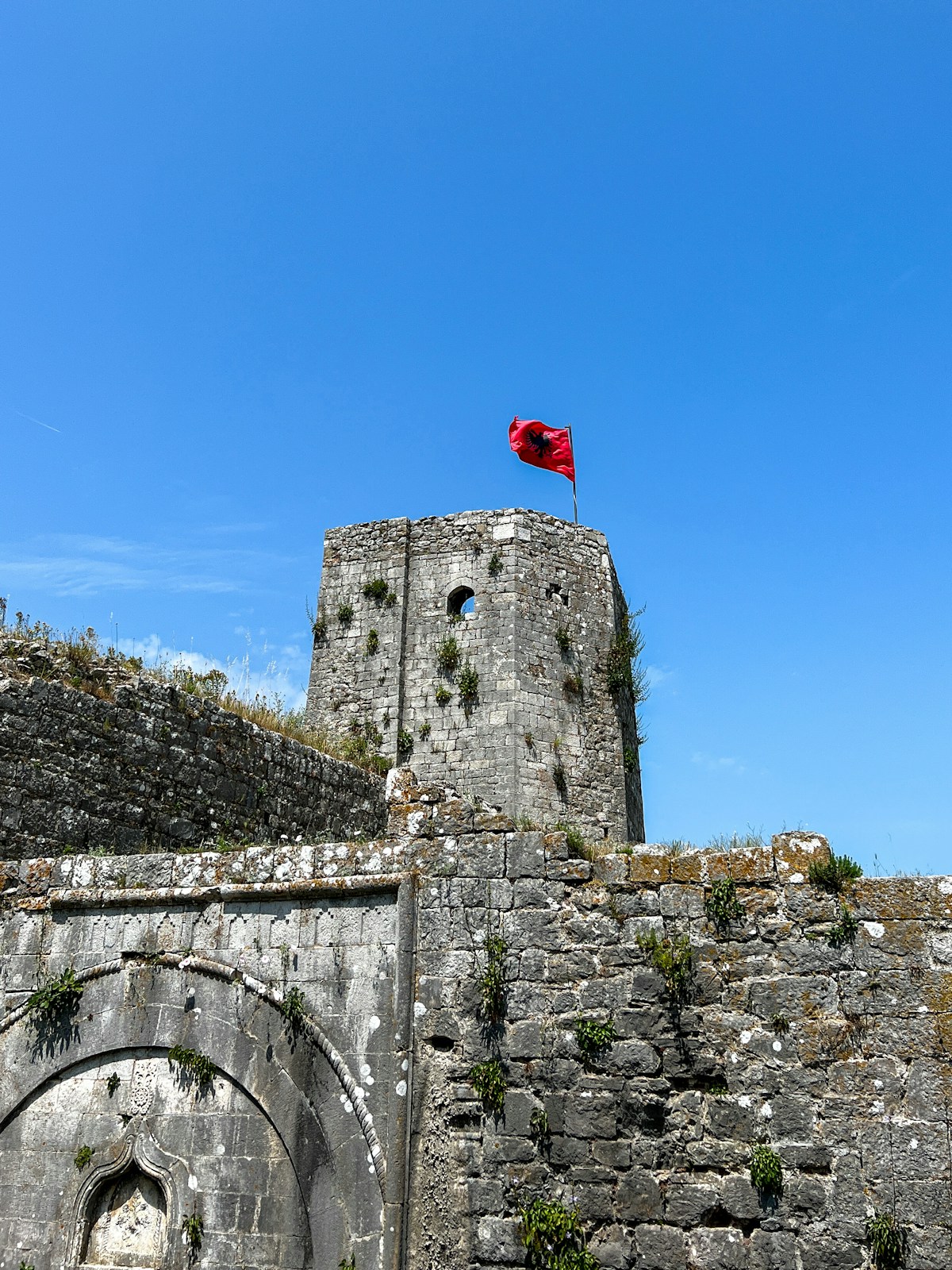 Albanian castle with red flag flying above the fortified walls