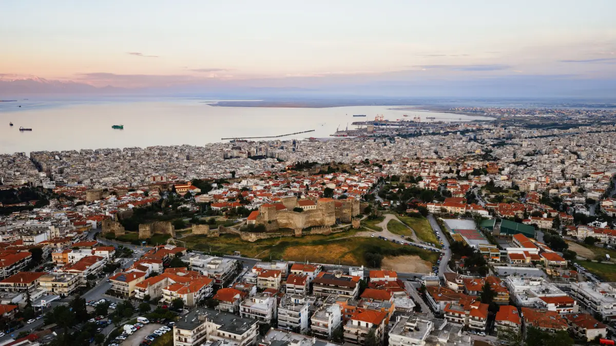 Aerial view of Thessaloniki cityscape with the Byzantine fortress and seafront at sunset, Greece