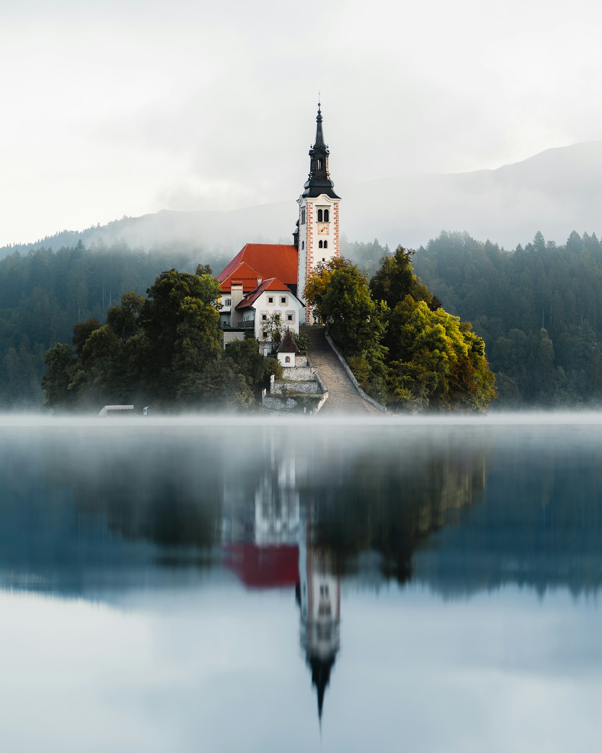Inselkirche auf dem Bleder See bei Morgenrot mit Julischen Alpen im Hintergrund