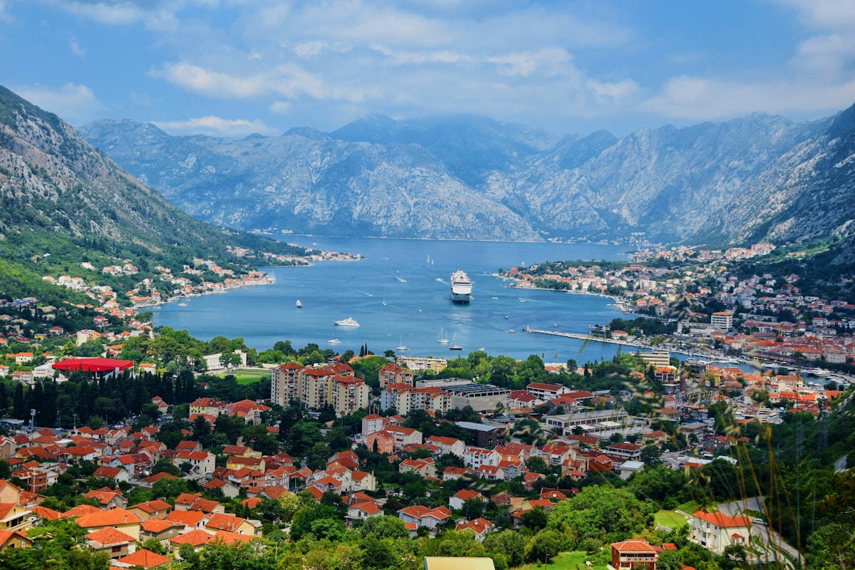 Aerial view of the Bay of Kotor in Montenegro, with cruise ship and the bay's dramatic mountain backdrop