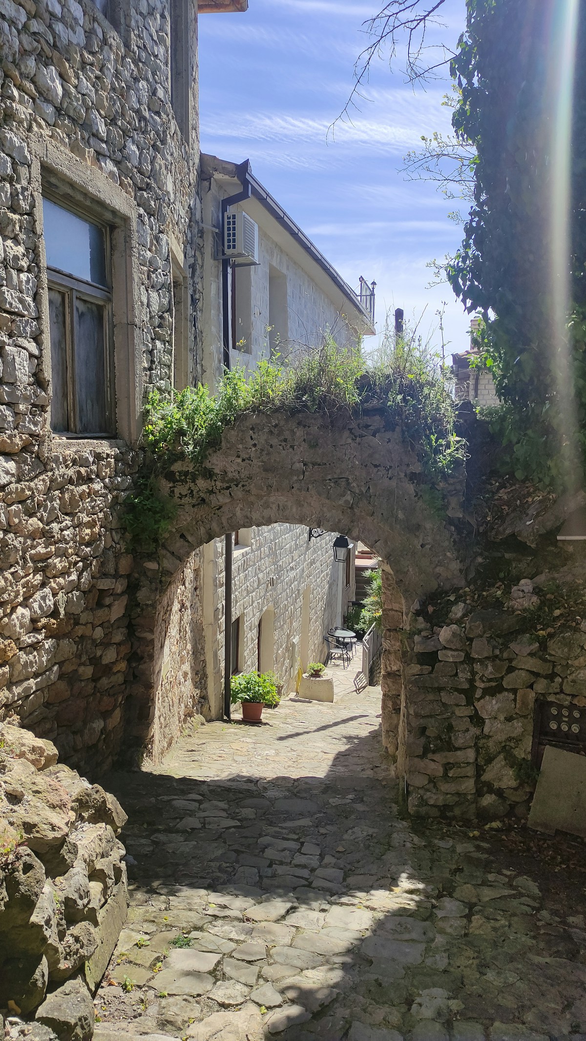 Narrow cobblestone street with a stone arch in Ulcinj Old Town, Montenegro