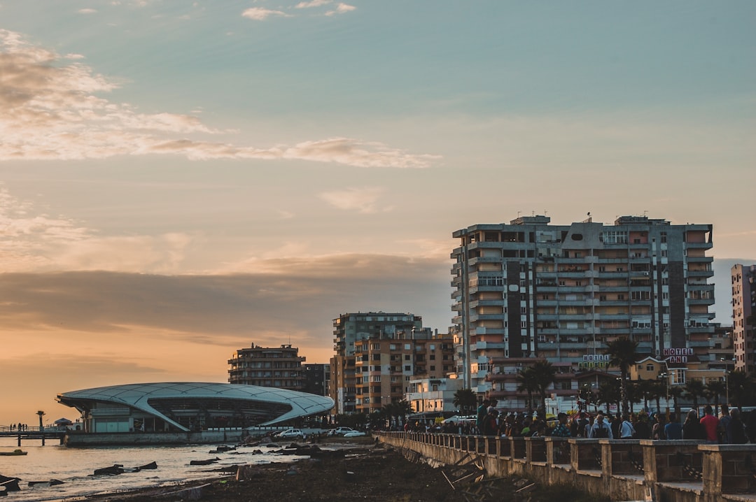 Durrës seafront promenade at sunset with the curved conference centre and apartment buildings along the Adriatic, Albania