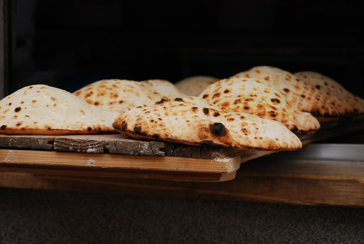 Freshly baked somun flatbreads on a wooden board — Sarajevo, Bosnia and Herzegovina