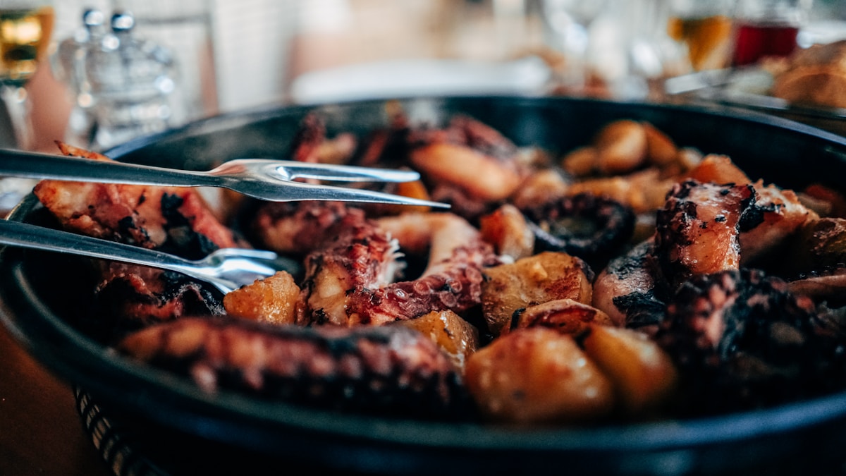 Cooked octopus with potatoes in a black peka pan — Adriatic seafood, Hvar, Croatia