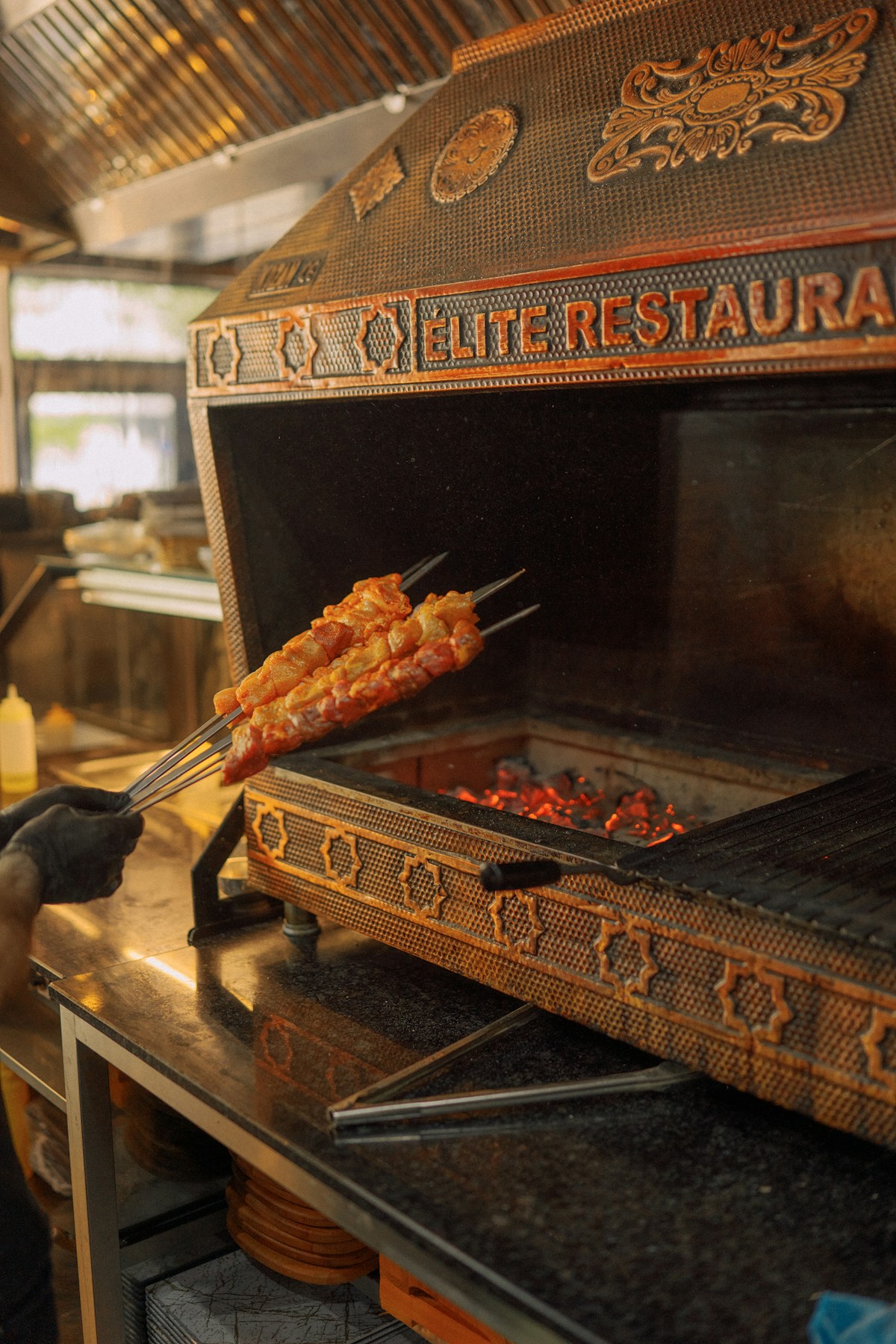 Meat skewers being grilled over hot coals at a traditional restaurant in Kosovo