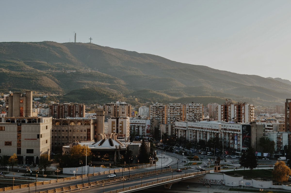 Skopje skyline at dusk with the Millennium Cross visible on Vodno Mountain above the city