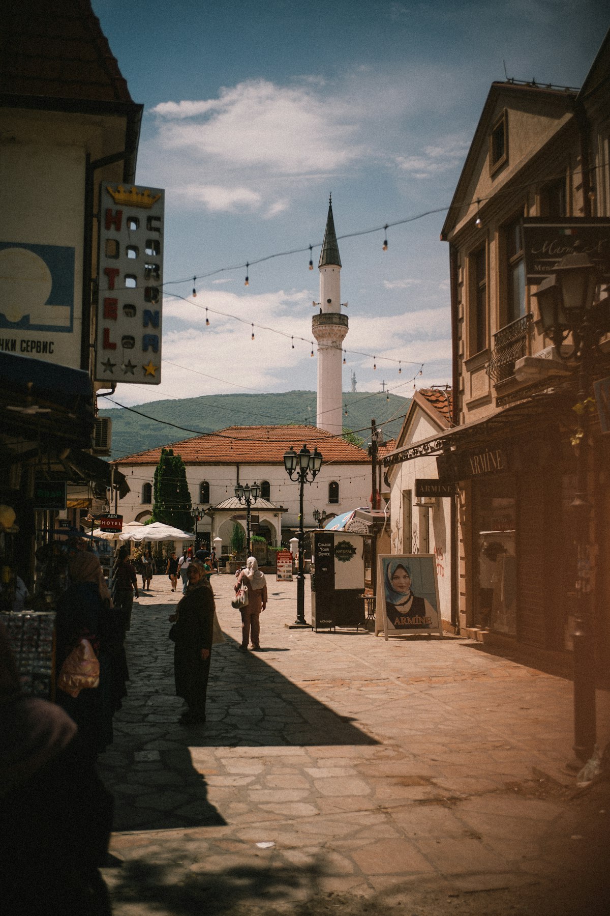 Historic street in Skopje Old Bazaar with mosque minaret and local shops, North Macedonia