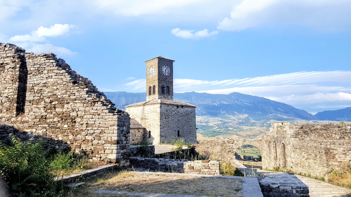 Stone-brick building with mountain backdrop in Gjirokaster old town, Albania