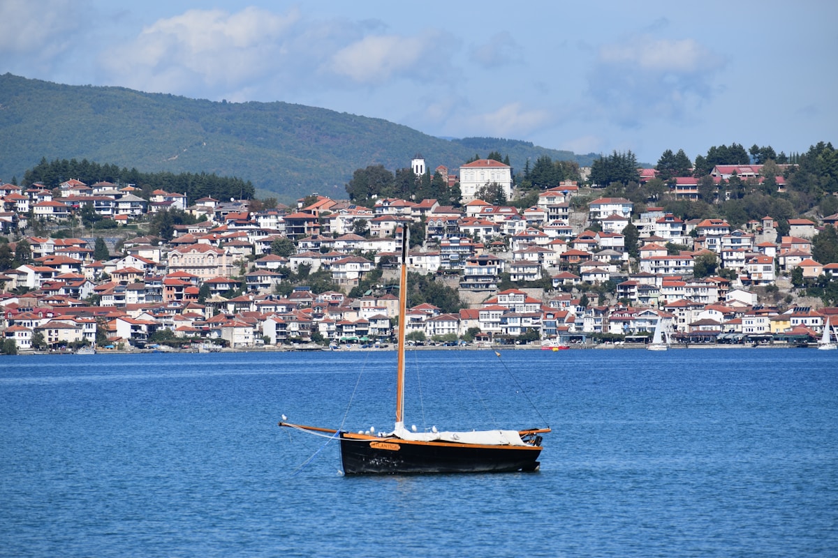 Traditional wooden boat on Lake Ohrid with the old town of Ohrid in the background, North Macedonia