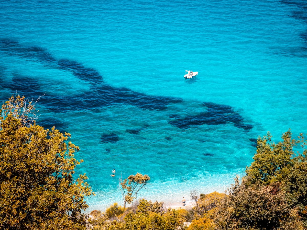 Crystal turquoise water of the Albanian Riviera near Ksamil, viewed from a hillside with vegetation