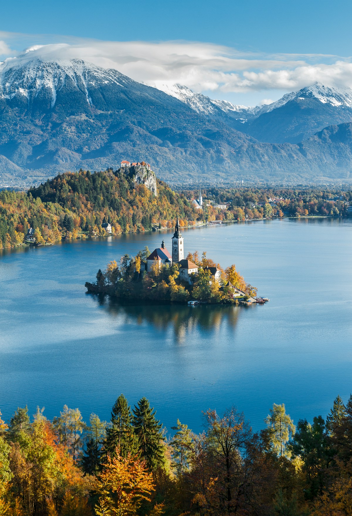 Bled Island church with the Julian Alps and autumn forest behind, Lake Bled, Slovenia