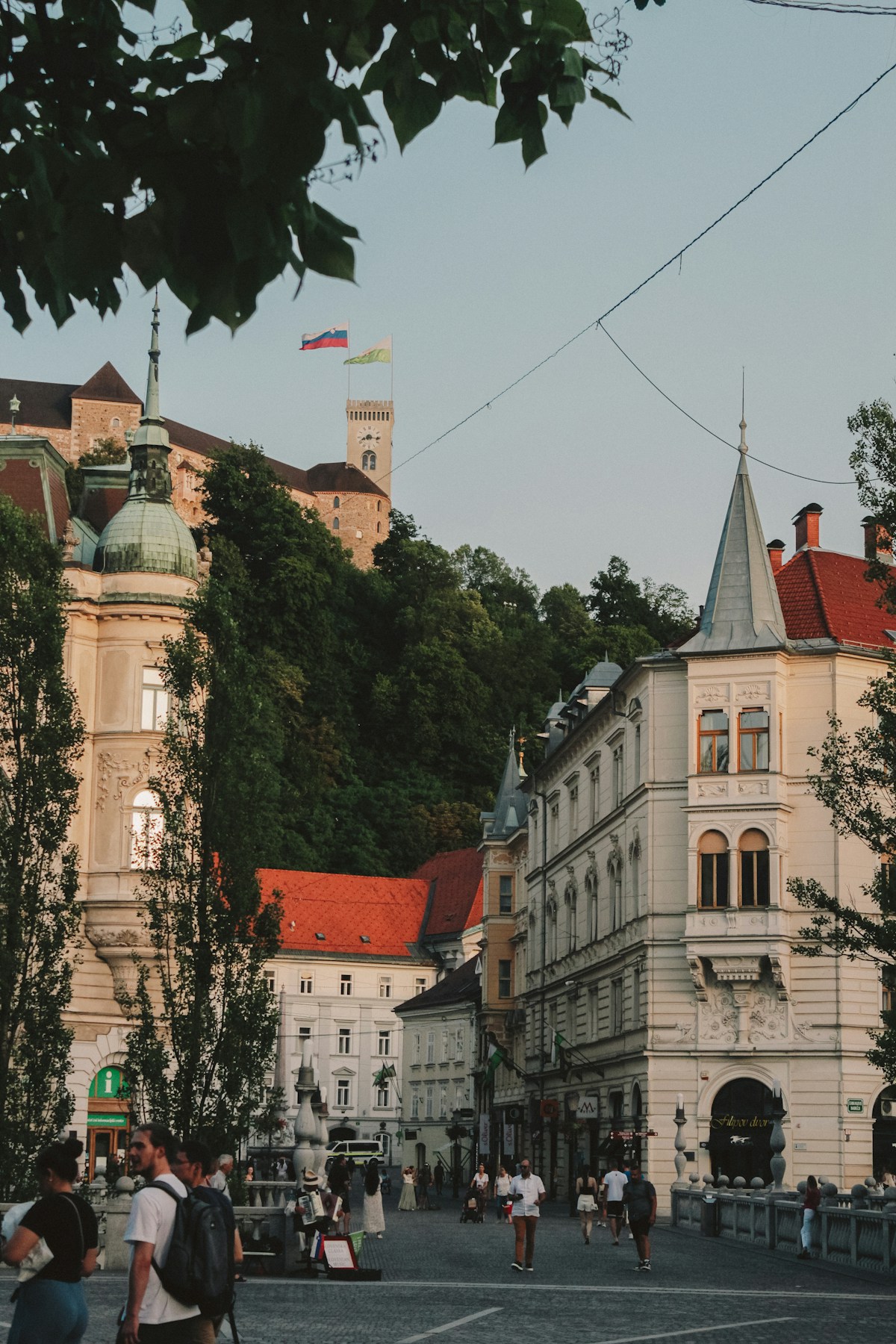 People walking down a street lined with tall buildings in Ljubljana, Slovenia