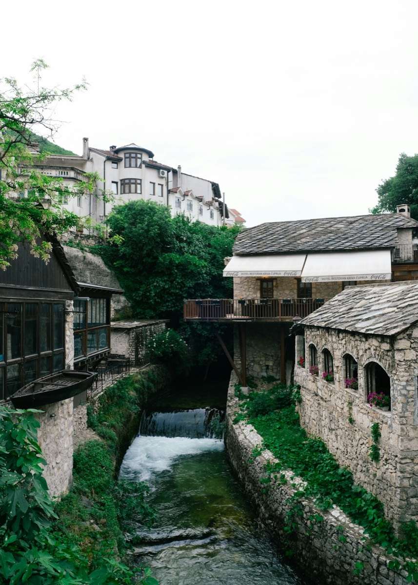 River running through Mostar with surrounding buildings, Bosnia and Herzegovina