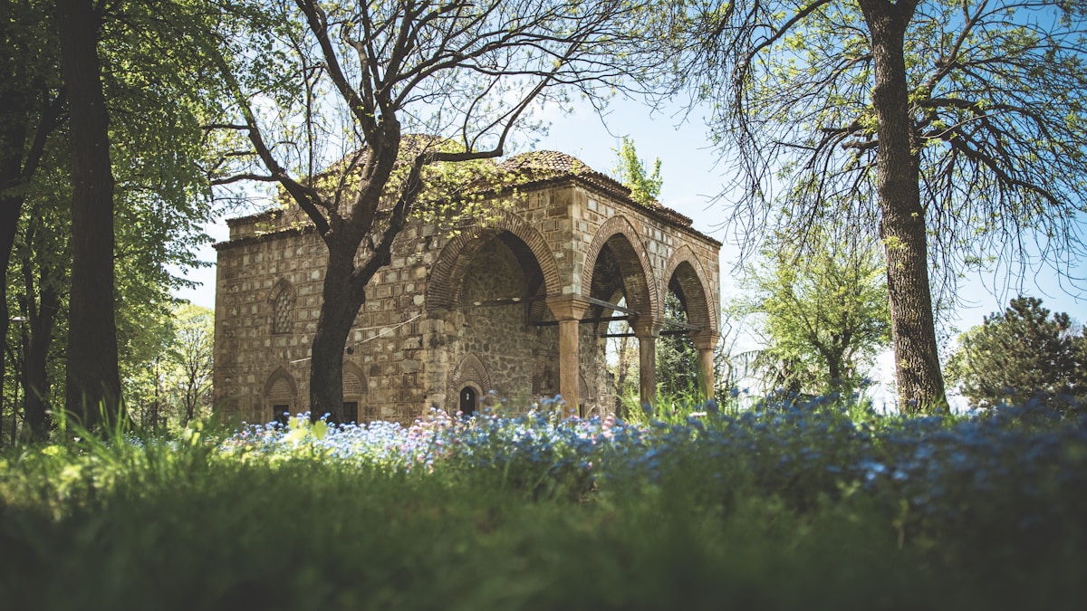 Stone building with arched windows surrounded by spring flowers in Niš, Serbia