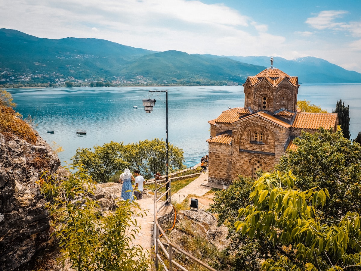 Visitors at St John at Kaneo Church with Lake Ohrid backdrop, North Macedonia