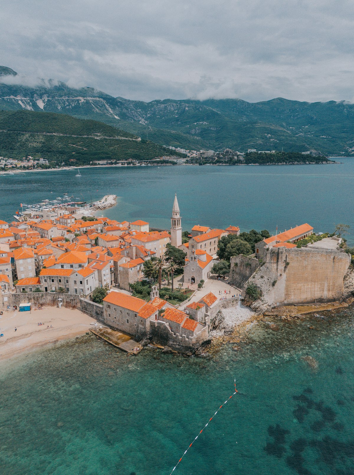 Aerial view of Budva Old Town peninsula surrounded by turquoise Adriatic Sea, Montenegro