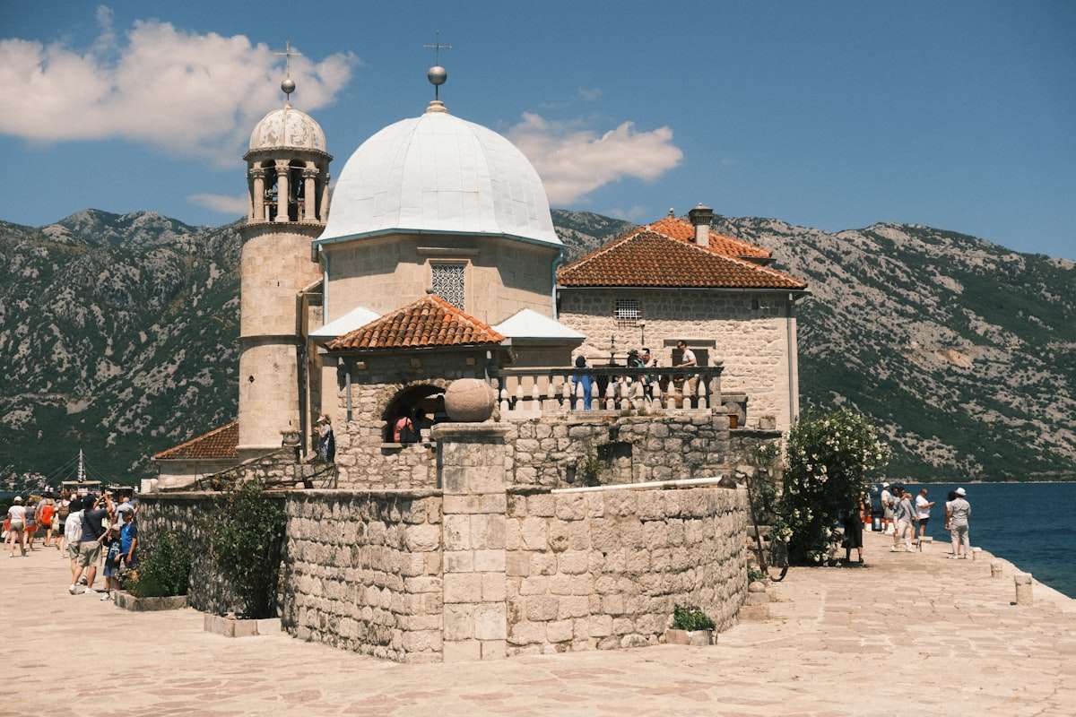 Bay of Kotor waterfront with sailboats and orange-roofed old town buildings, Montenegro