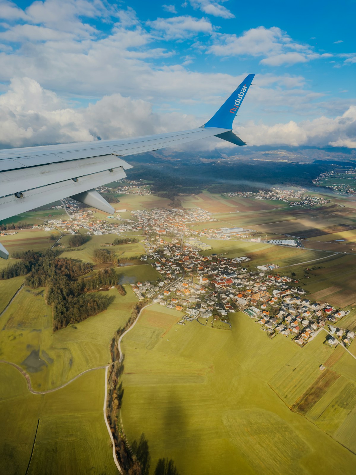 Airplane wing over a rural village in Slovenia