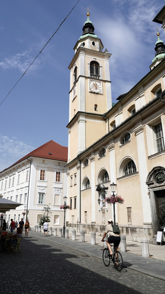 Cyclist in front of a building in Ljubljana, Slovenia - Ljubljana vs Zagreb