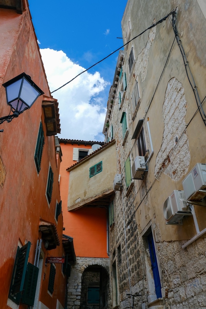 Narrow alleyway with green shutters in Rovinj, Istria, Croatia