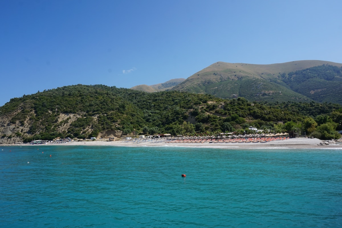 Beach bar at Buneci Beach with mountain backdrop on the Albanian Riviera
