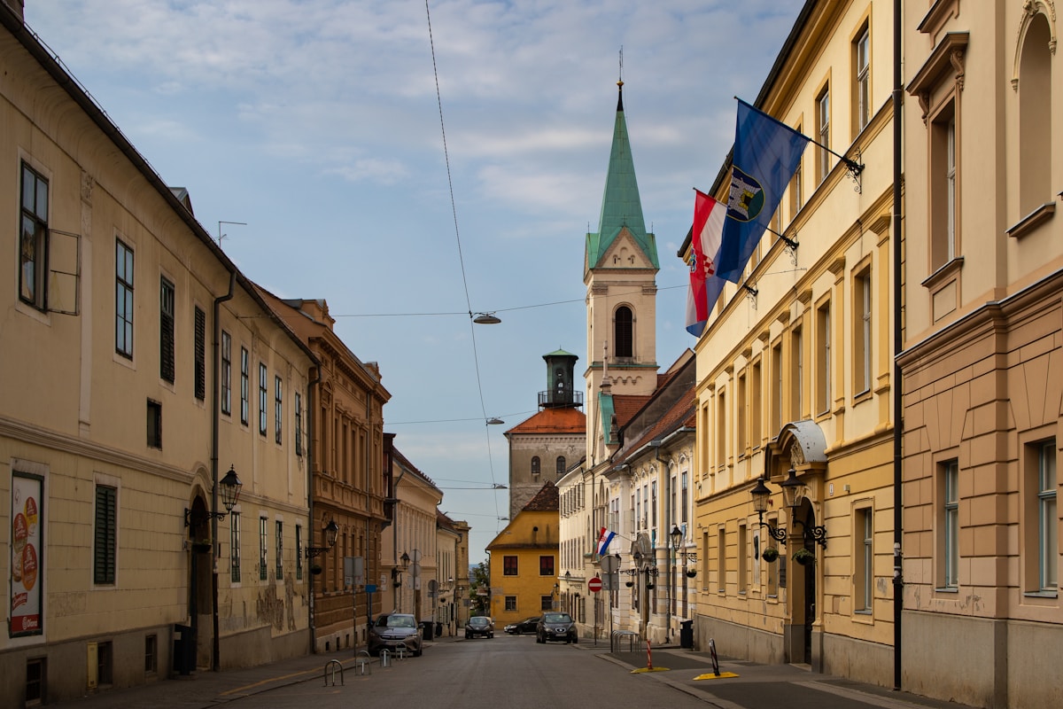 Street in Zagreb upper town with Croatian flags and church spire, Croatia